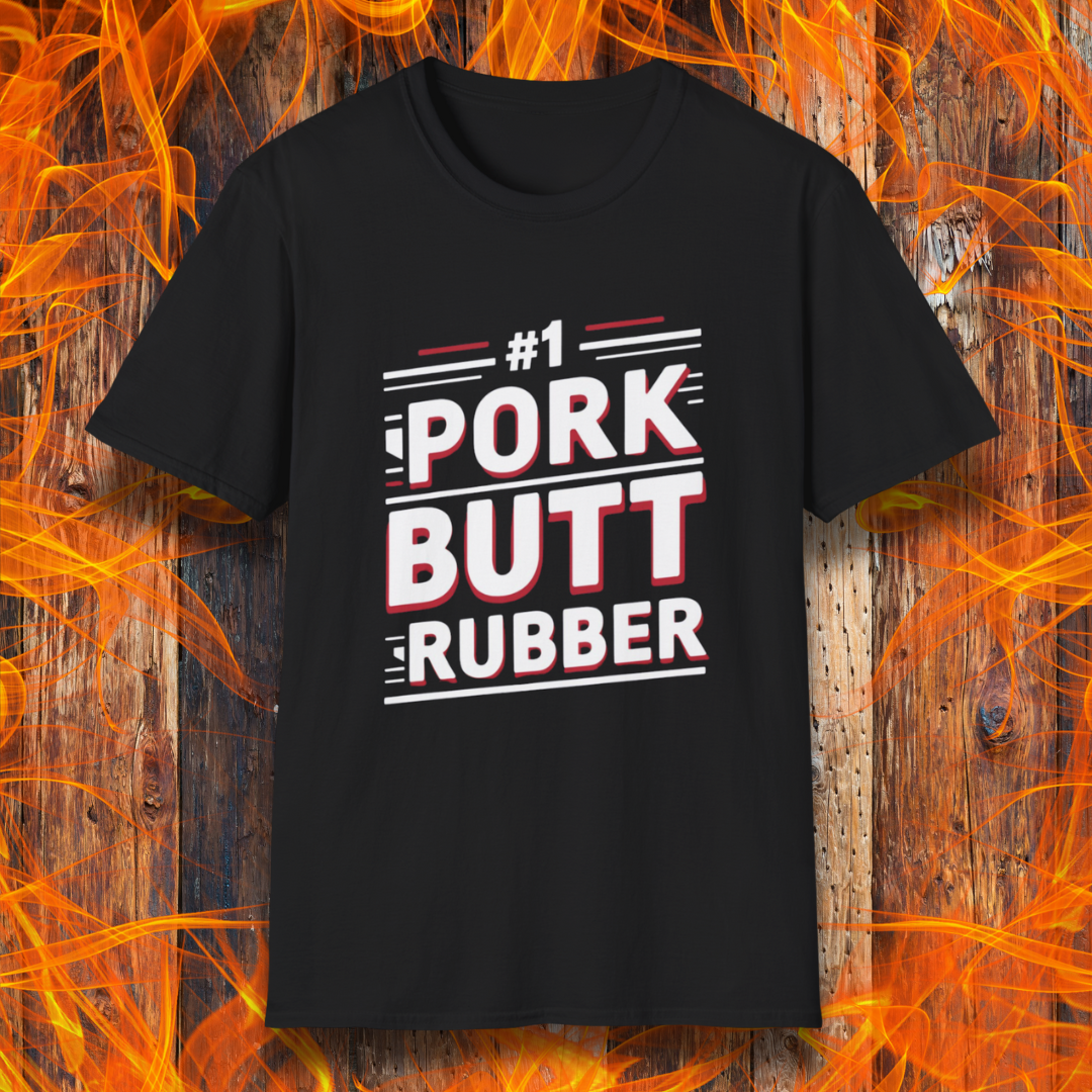 Black T-shirt featuring a bold, humorous BBQ-themed design that reads '#1 PORK BUTT RUBBER' in red and white block lettering with stylish line accents. A fun shirt for grill masters and barbecue enthusiasts.