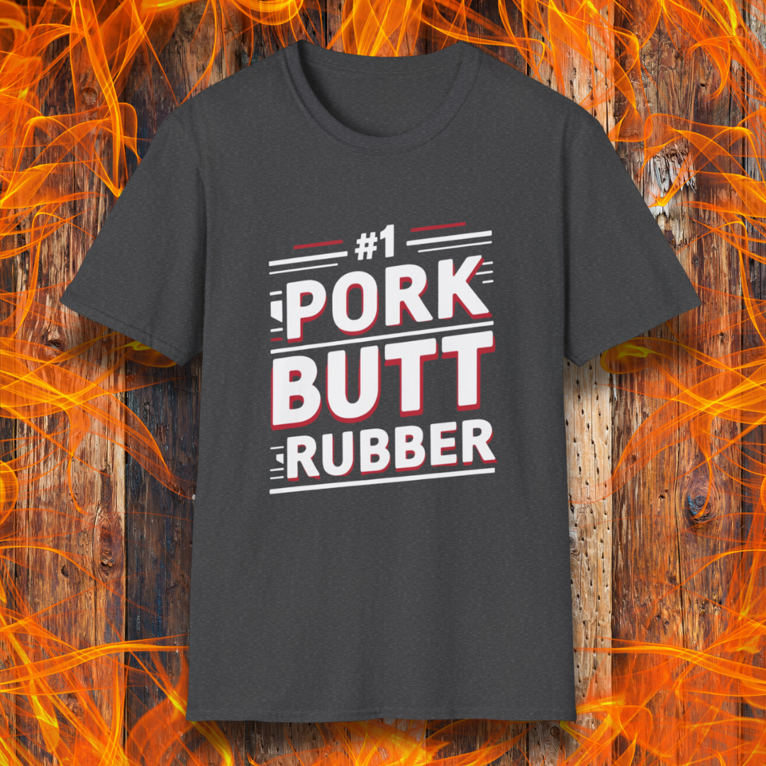 Dark Heather T-shirt featuring a bold, humorous BBQ-themed design that reads '#1 PORK BUTT RUBBER' in red and white block lettering with stylish line accents. A fun shirt for grill masters and barbecue enthusiasts.