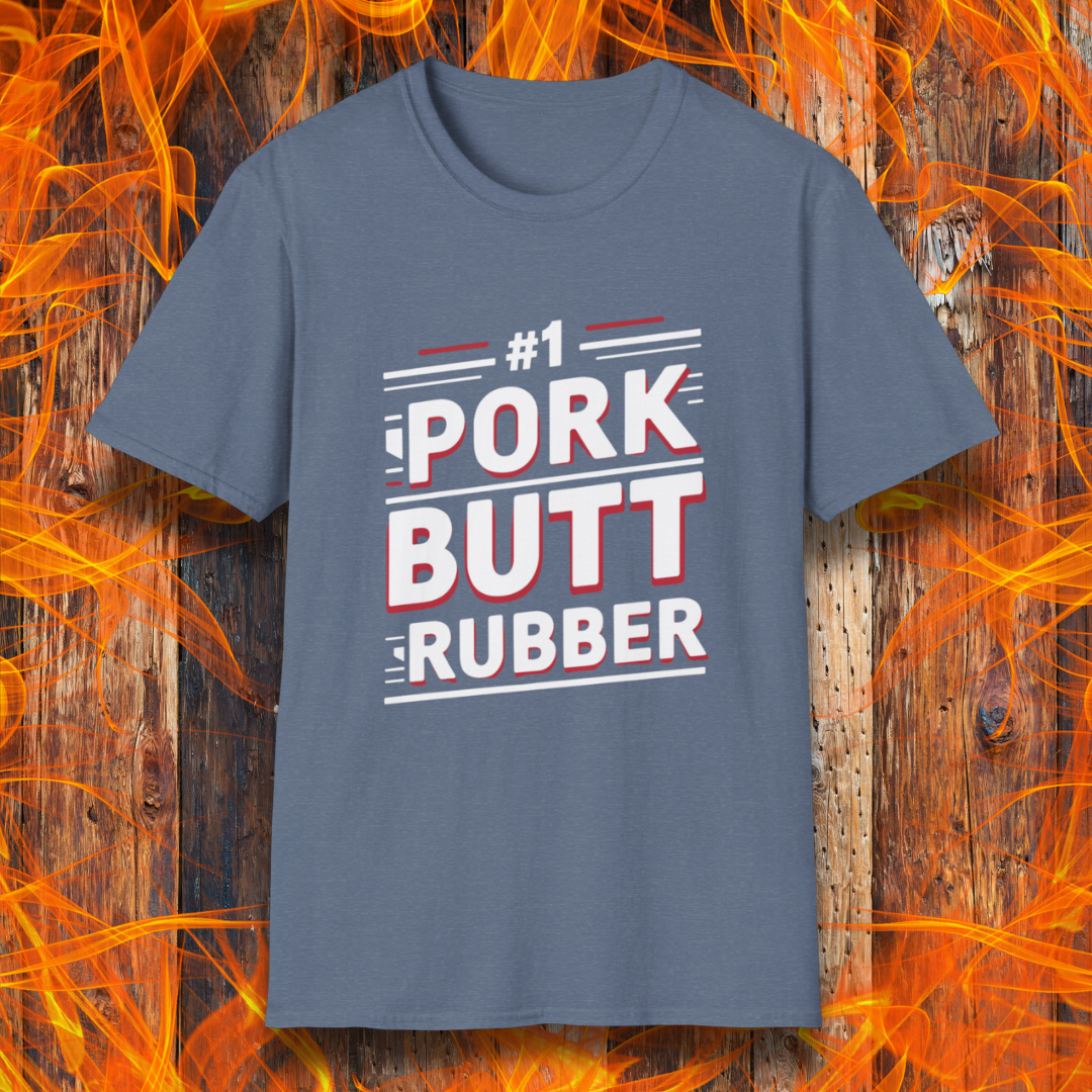 Heather Indigo T-shirt featuring a bold, humorous BBQ-themed design that reads '#1 PORK BUTT RUBBER' in red and white block lettering with stylish line accents. A fun shirt for grill masters and barbecue enthusiasts.