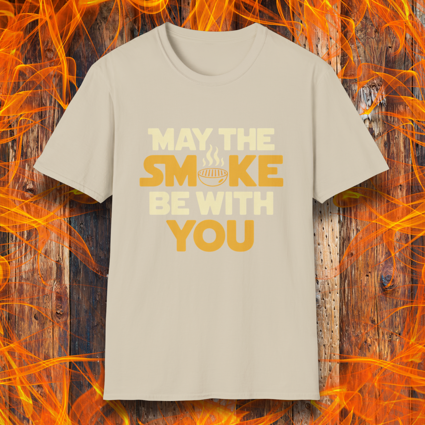 Tan t-shirt with the phrase "May The Smoke Be With You" on a wooden fire background.
