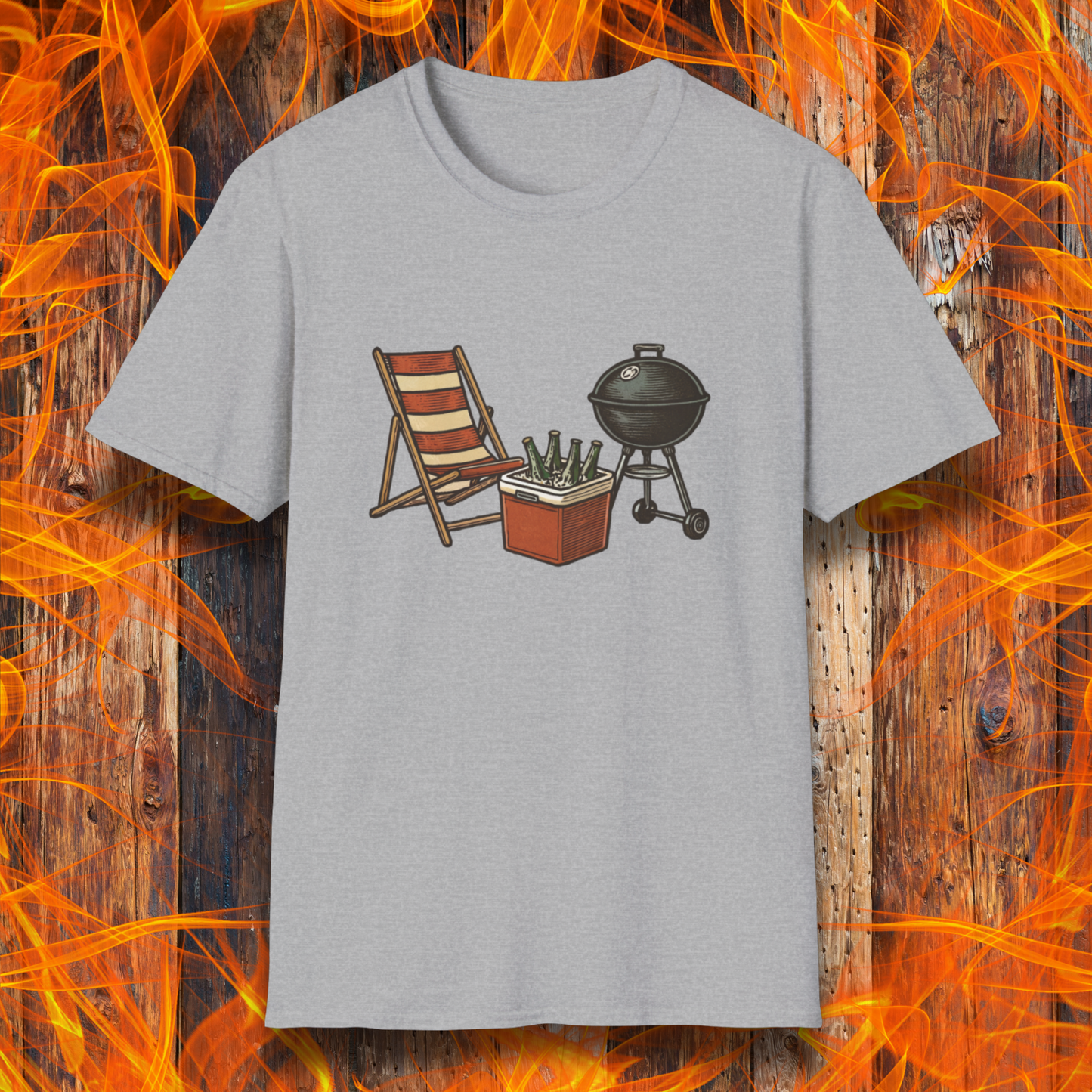 Gray t-shirt with a graphic of a grill, chair, and cooler on a wooden background with flames.