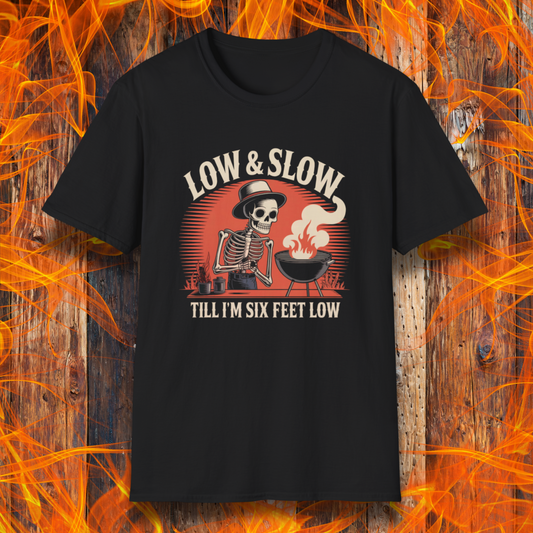 Black t-shirt with a graphic design featuring a skeleton and text 'Low & Slow Till I'm Six Feet Low' on a wooden background with flames.