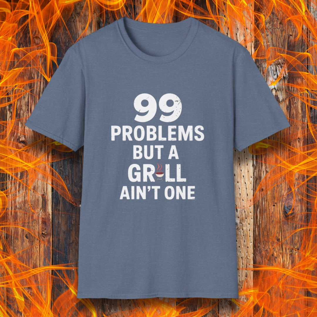 Heather Indigo T-shirt with bold white text that says "99 Problems But a Grill Ain’t One," featuring a small red grill icon replacing the "I" in "Grill" — a playful shirt for BBQ fans and grilling pros.