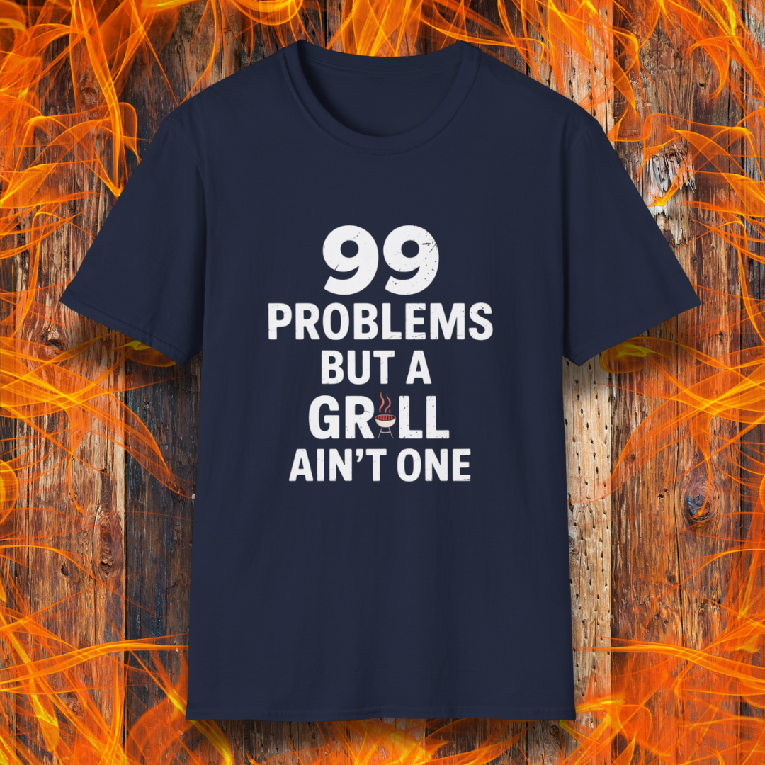 Navy T-shirt with bold white text that says "99 Problems But a Grill Ain’t One," featuring a small red grill icon replacing the "I" in "Grill" — a playful shirt for BBQ fans and grilling pros.