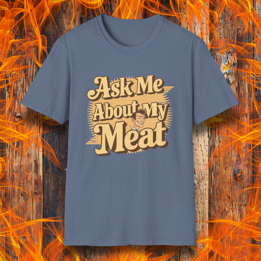 Heather Indigo T-shirt featuring a retro-style design with the phrase 'Ask Me About My Meat' in bold, vintage lettering. The text is accented with a smiling, cartoon-style character, giving it a humorous and playful BBQ-themed vibe.