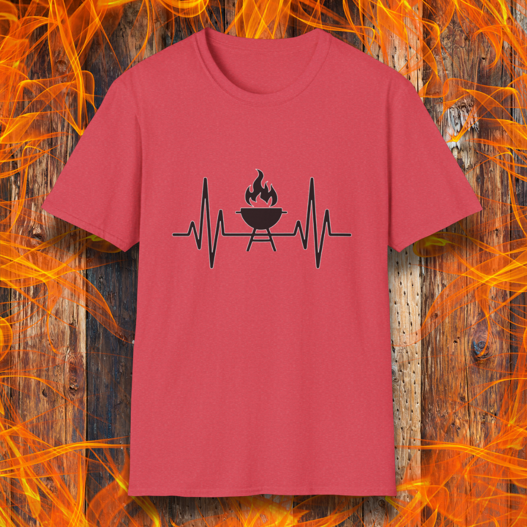 Heather Red T-shirt featuring a minimalist black design of a heartbeat line that transitions into a flaming charcoal grill in the center. The design symbolizes a passion for BBQ, integrating a clean and modern aesthetic. The background consists of a rustic wooden surface with vivid orange flames, enhancing the fiery and grilling-focused theme.