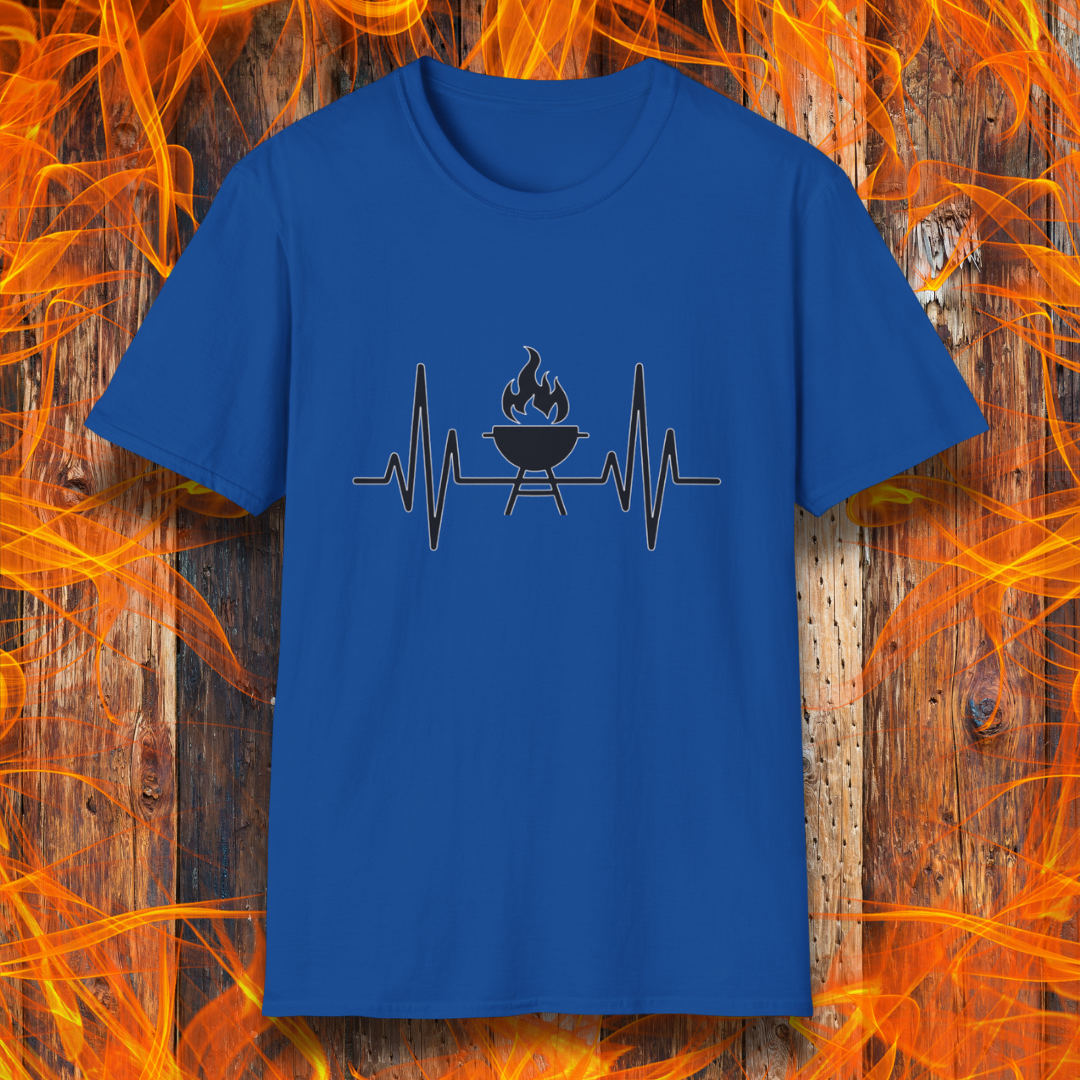 Royal Blue T-shirt featuring a minimalist black design of a heartbeat line that transitions into a flaming charcoal grill in the center. The design symbolizes a passion for BBQ, integrating a clean and modern aesthetic. The background consists of a rustic wooden surface with vivid orange flames, enhancing the fiery and grilling-focused theme.