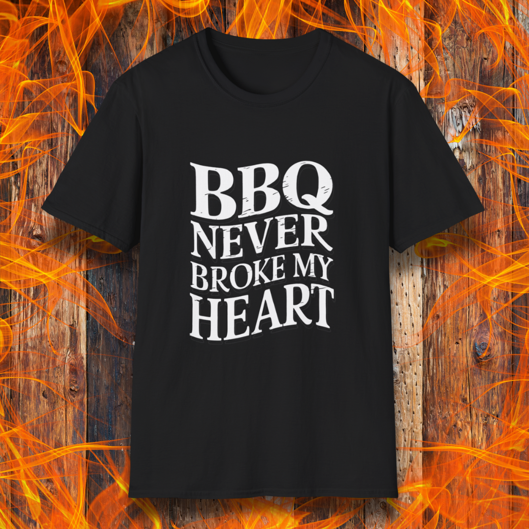 Black t-shirt featuring bold white text that reads 'BBQ Never Broke My Heart' in a rustic, slightly distressed font, perfect for barbecue lovers who stay loyal to great smoked meats.
