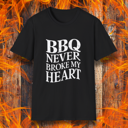 Black t-shirt featuring bold white text that reads 'BBQ Never Broke My Heart' in a rustic, slightly distressed font, perfect for barbecue lovers who stay loyal to great smoked meats.
