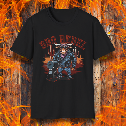 Black T-shirt featuring a bold and rebellious BBQ-themed design. The centerpiece is an anthropomorphic bull dressed like a biker, wearing a black leather jacket, blue jeans, and a red bandana, exuding a tough and confident attitude. He stands next to a classic barrel-style smoker. The background includes red flames and grill forks, adding to the edgy, fiery vibe. Above the character, "BBQ REBEL" is displayed in bold, vintage-style red lettering.