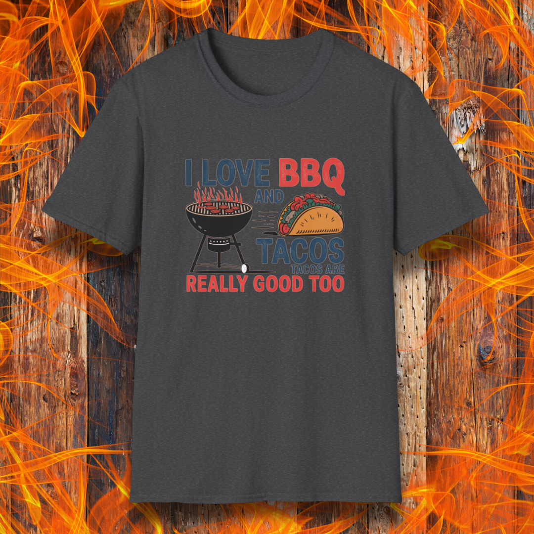 Dark Heather T-shirt features a fun and bold design that reads, "I Love BBQ and Tacos... Tacos Are Really Good Too," with graphics of a flaming grill and a delicious taco. Perfect for BBQ lovers who also enjoy a good taco, this shirt combines humor and food passion in a stylish way.