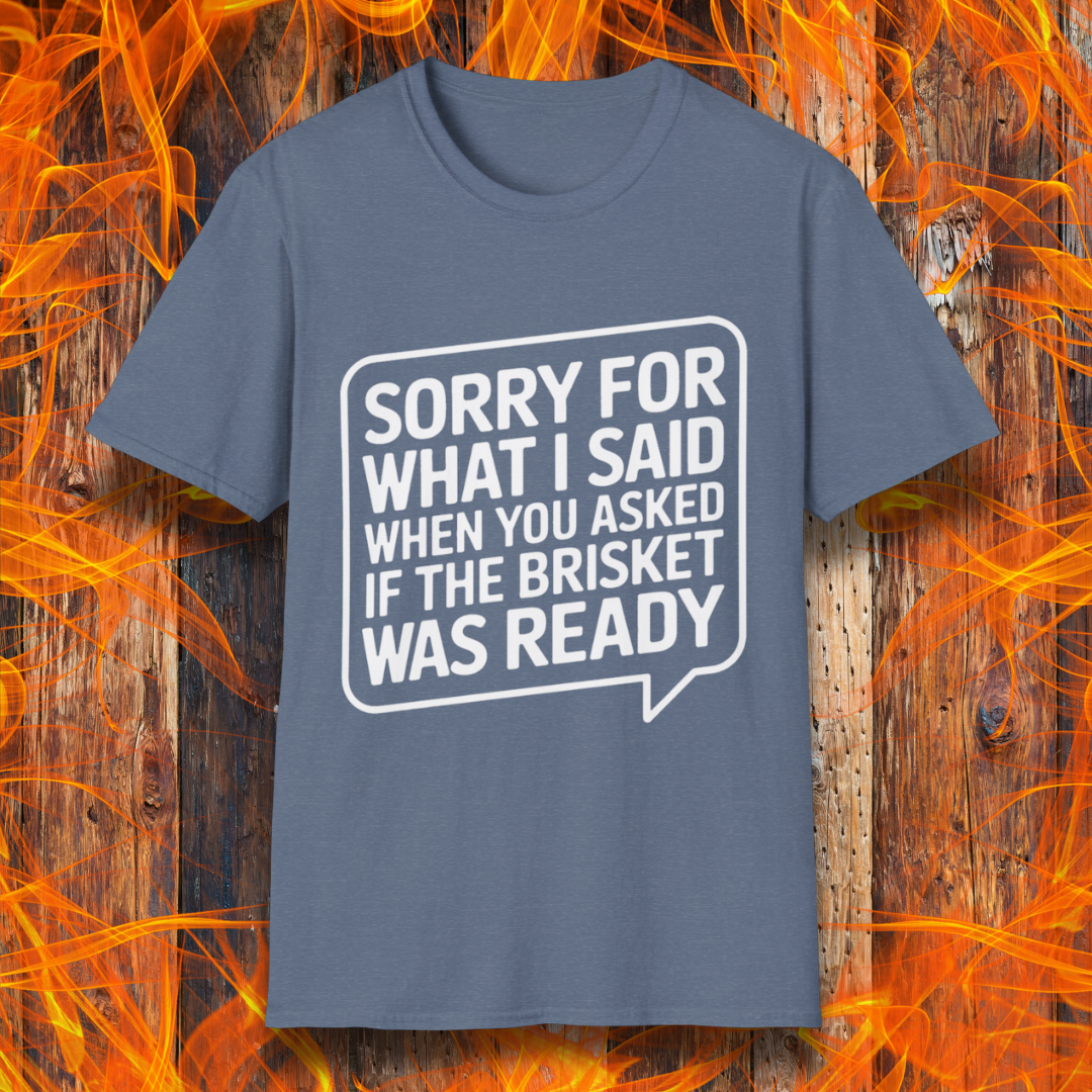 Heather Indigo T-shirt with bold white text inside a speech bubble that reads, "Sorry for what I said when you asked if the brisket was ready." A fun and relatable design for BBQ lovers and pitmasters.