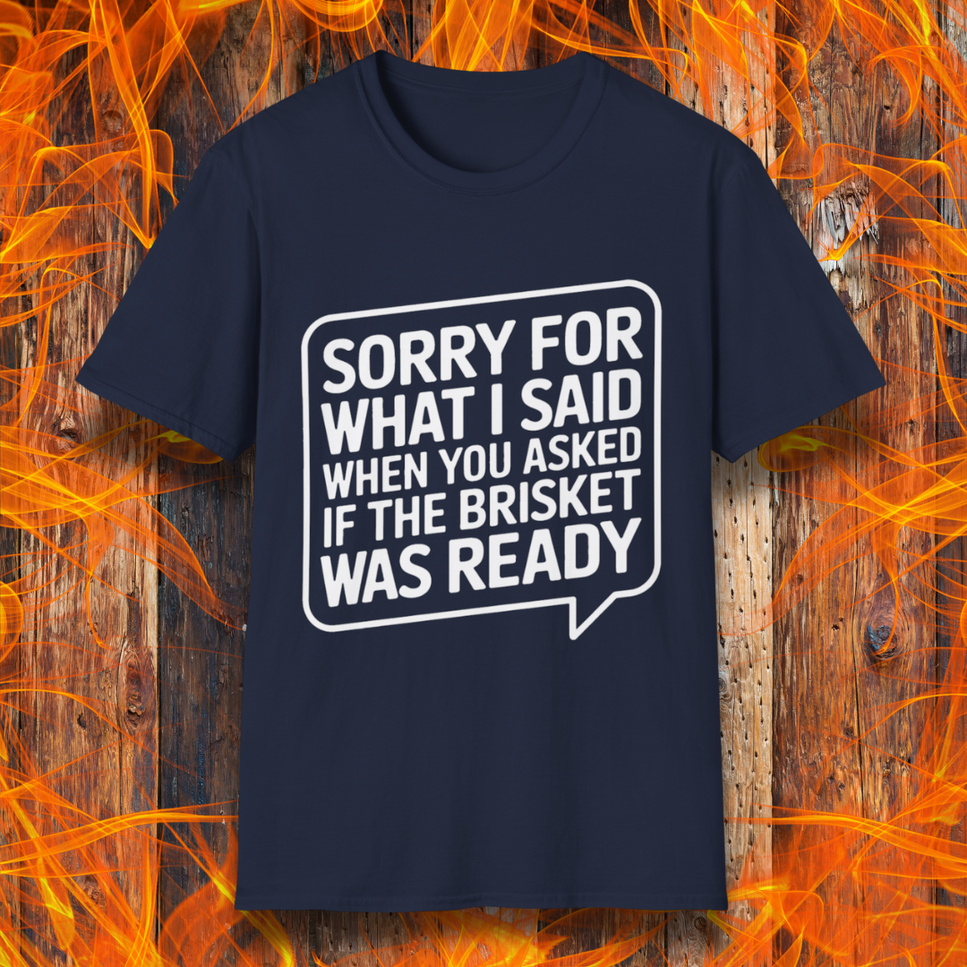 Navy T-shirt with bold white text inside a speech bubble that reads, "Sorry for what I said when you asked if the brisket was ready." A fun and relatable design for BBQ lovers and pitmasters.