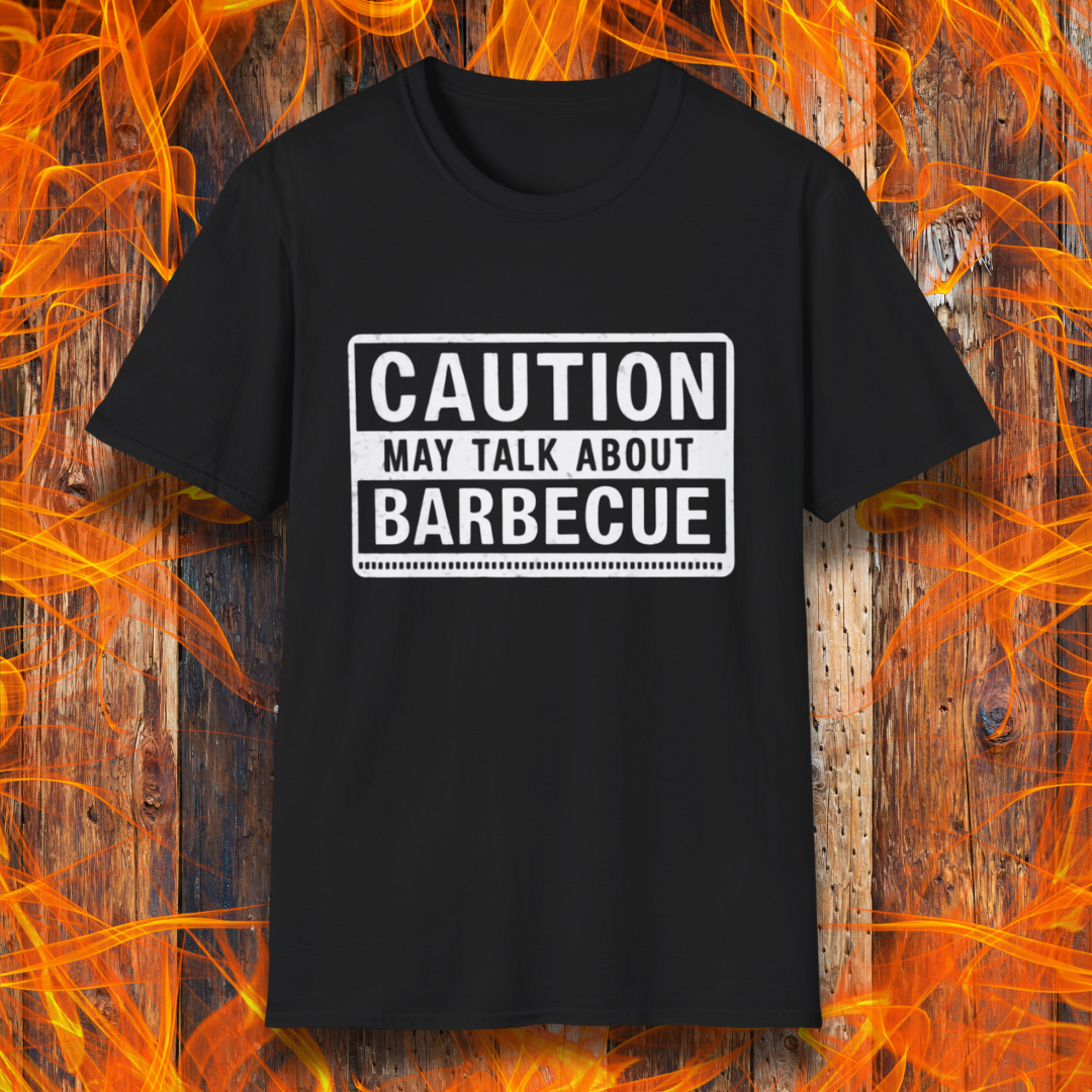 Black T-shirt featuring a bold, high-contrast design resembling a caution sign. The text reads 'CAUTION MAY TALK ABOUT BARBECUE' in white, with a distressed effect, making it perfect for BBQ enthusiasts who love to chat about grilling.