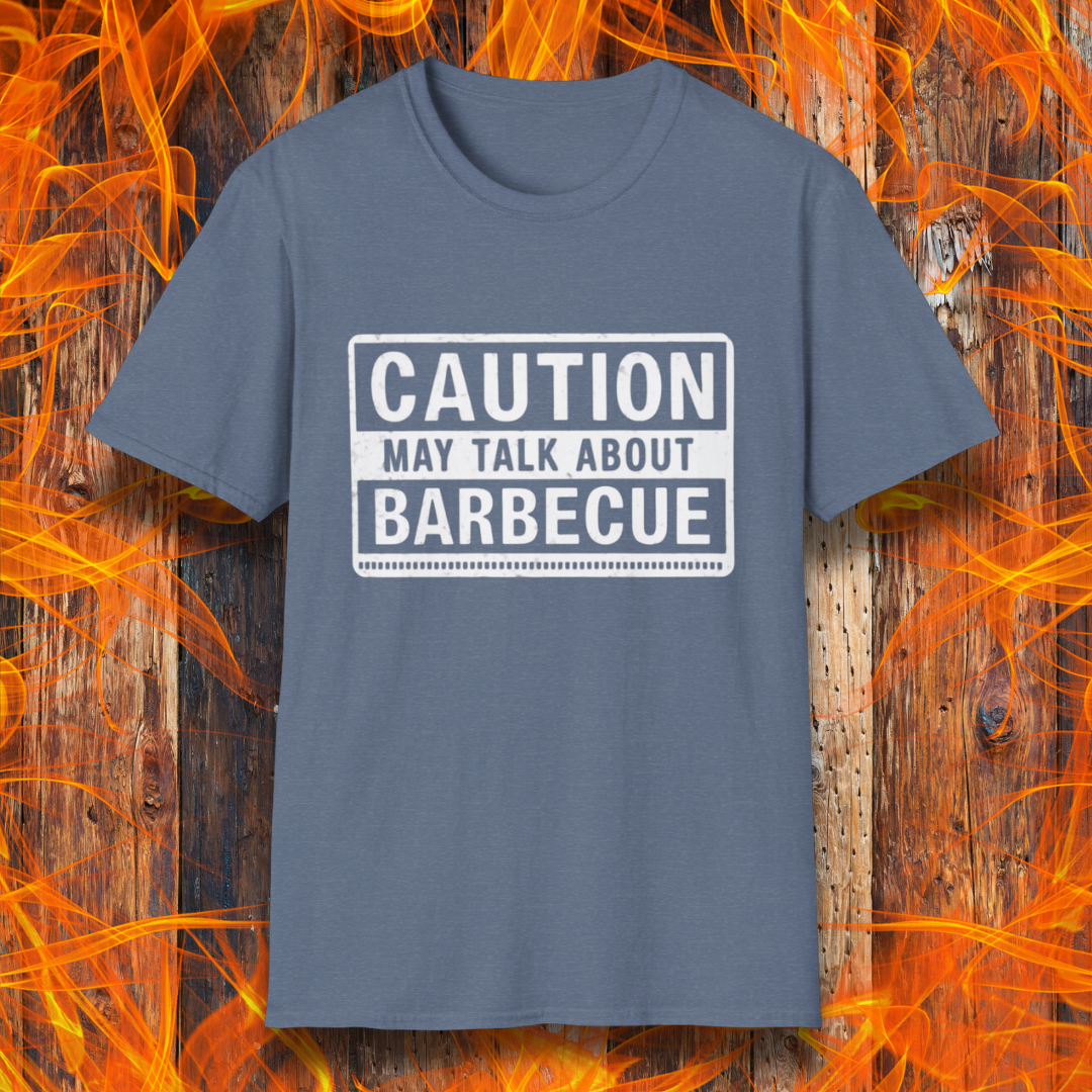 Heather Indigo T-shirt featuring a bold, high-contrast design resembling a caution sign. The text reads 'CAUTION MAY TALK ABOUT BARBECUE' in white, with a distressed effect, making it perfect for BBQ enthusiasts who love to chat about grilling.