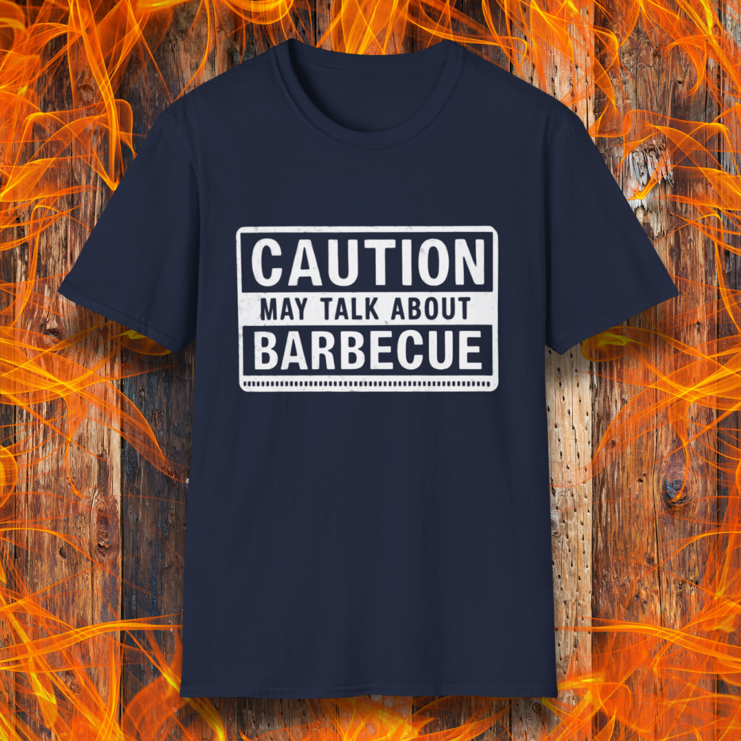 Navy T-shirt featuring a bold, high-contrast design resembling a caution sign. The text reads 'CAUTION MAY TALK ABOUT BARBECUE' in white, with a distressed effect, making it perfect for BBQ enthusiasts who love to chat about grilling.