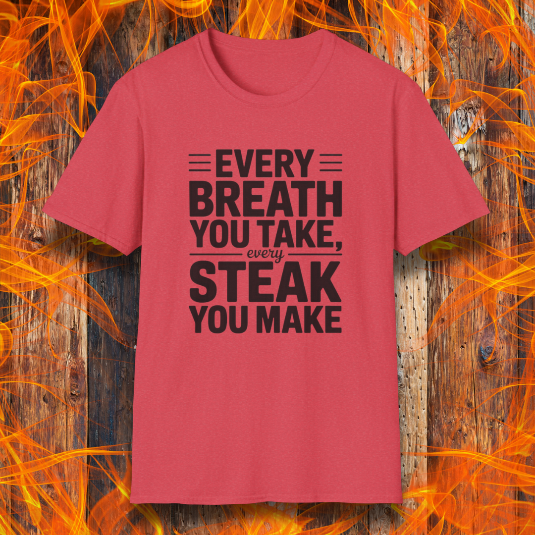 Heather Red T-shirt with bold white text that reads "Every Breath You Take, Every Steak You Make," displayed over a rustic wood and flame background — a humorous grilling shirt perfect for steak fans.