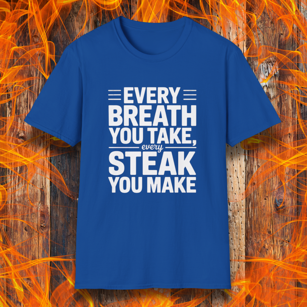 Royal Blue T-shirt with bold white text that reads "Every Breath You Take, Every Steak You Make," displayed over a rustic wood and flame background — a humorous grilling shirt perfect for steak fans.