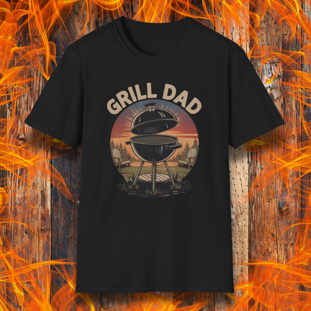 Black t-shirt with 'Grill Dad' graphic on a wooden background with flames.