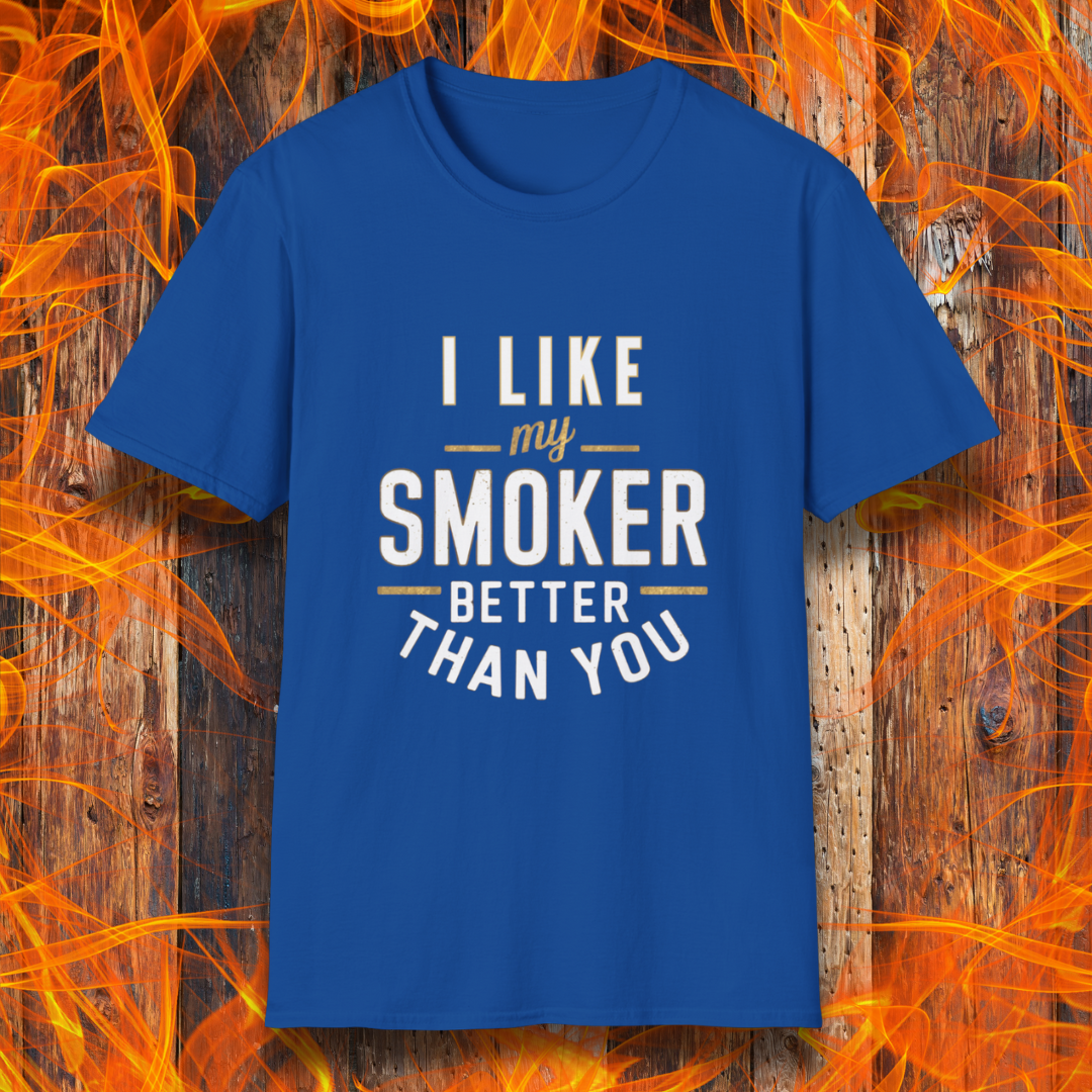 Royal Blue T-shirt featuring a witty BBQ-themed design. The bold text reads 'I Like My Smoker Better Than You' in a mix of white and gold lettering, with decorative lines adding emphasis. A perfect shirt for grill masters and smoking enthusiasts with a sense of humor.