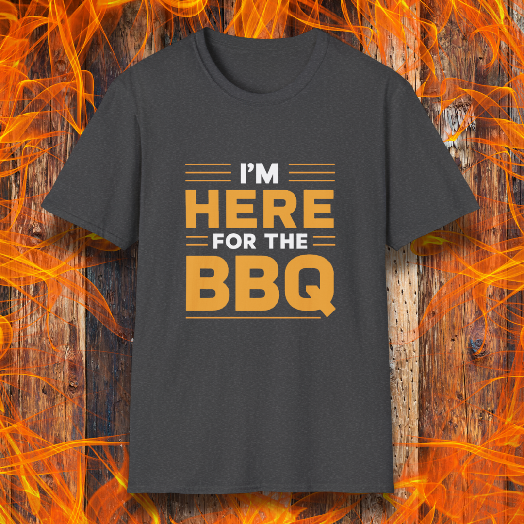 Dark Heather T-shirt with bold text reading 'I'M HERE FOR THE BBQ' in orange and white, accented with horizontal lines for emphasis. A stylish and fun design for BBQ lovers and grill masters.