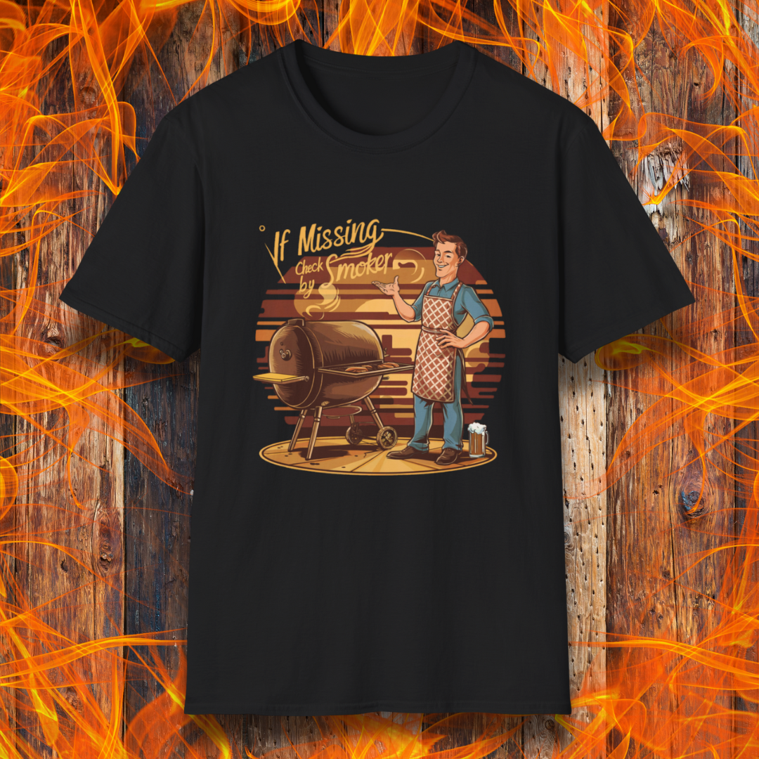 Black t-shirt featuring a retro-style illustration of a man grilling next to a smoker, with the phrase 'If Missing, Check by Smoker,' displayed against a fiery wooden background."