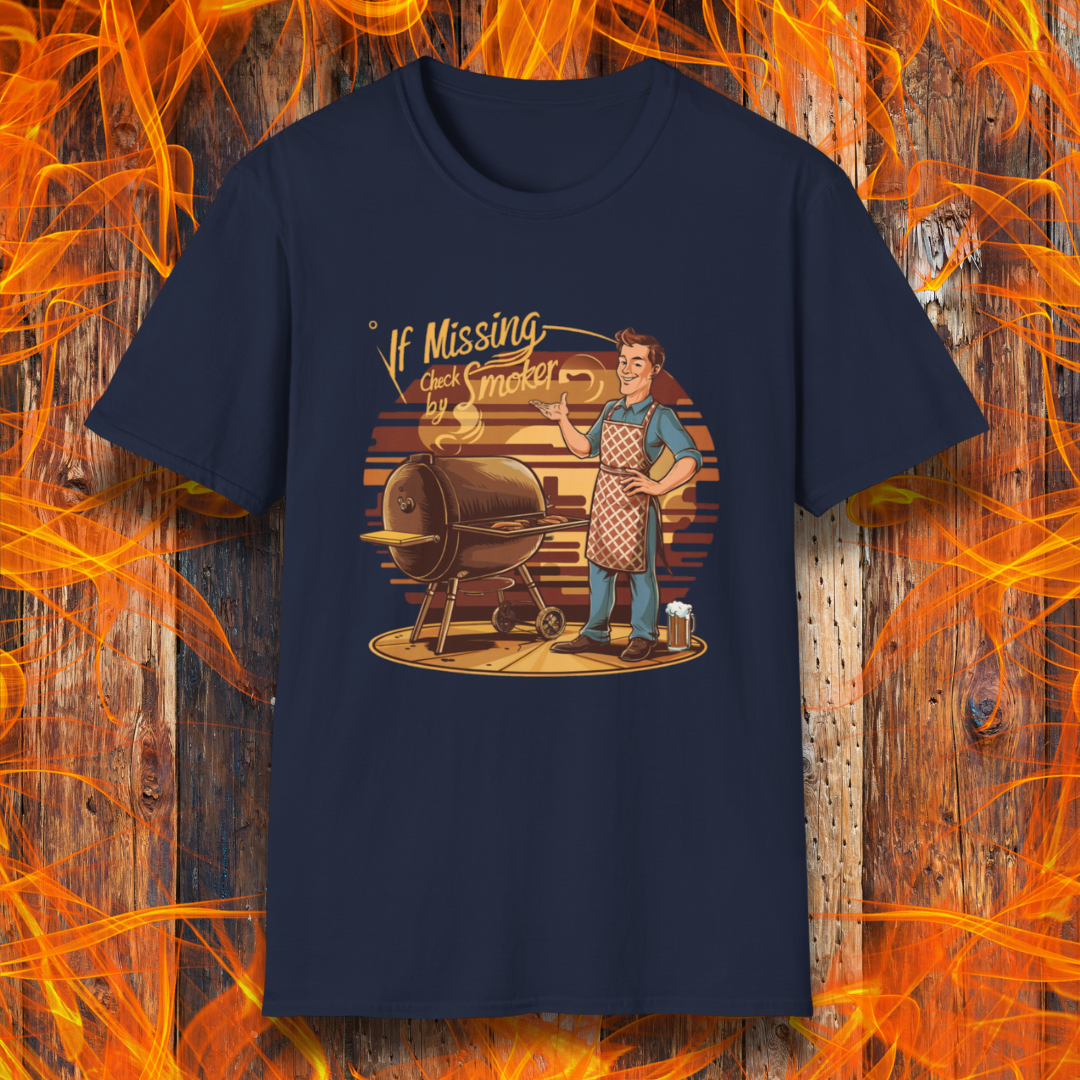 Navy t-shirt featuring a retro-style illustration of a man grilling next to a smoker, with the phrase 'If Missing, Check by Smoker,' displayed against a fiery wooden background."