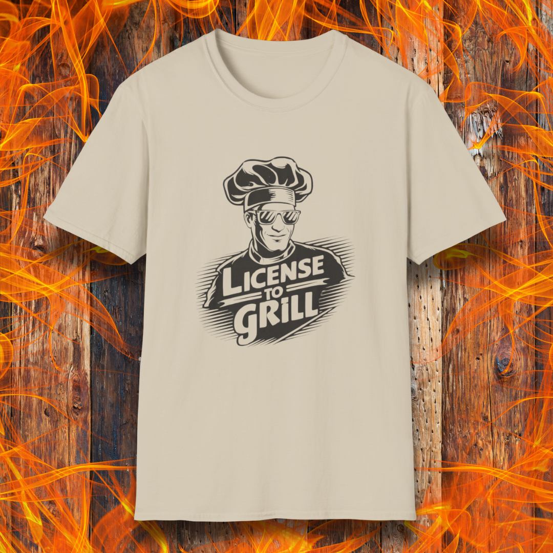 Sand t-shirt featuring a bold white graphic of a cool chef wearing sunglasses and a toque, with the phrase 'License to Grill' in a dynamic retro-style font.