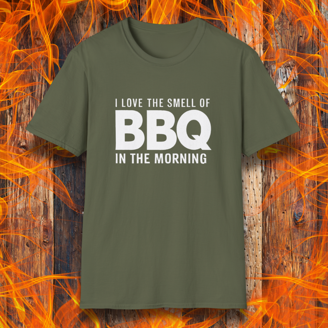 Military Green t-shirt with the phrase 'I Love the Smell of BBQ in the Morning' in bold white text, displayed against a fiery wooden background