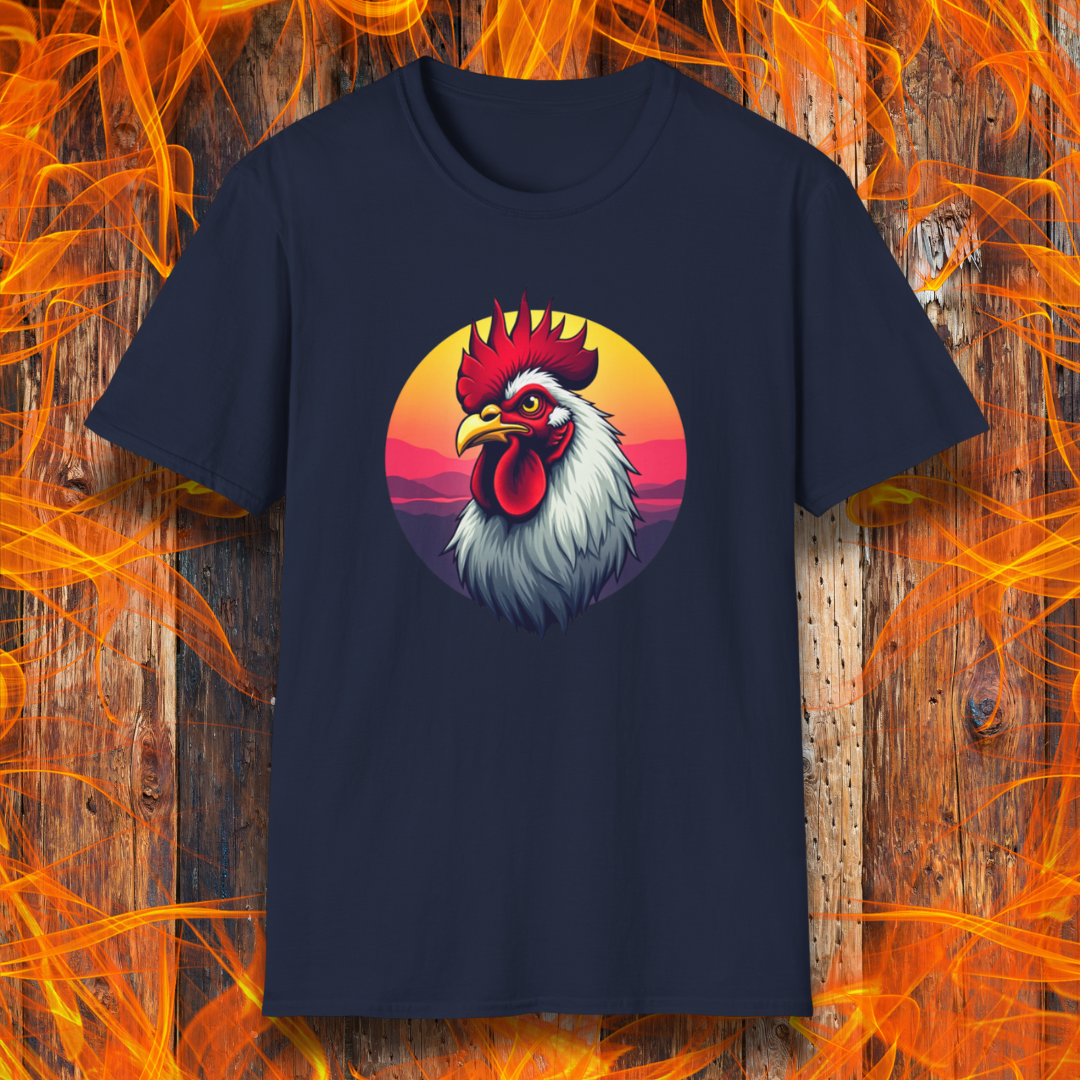 Navy T-shirt featuring a bold and colorful illustration of a rooster with a dramatic red comb and white feathers, set against a circular sunset background with warm hues of orange, pink, and purple. The design exudes a rustic and vibrant aesthetic, perfect for BBQ and farm-style enthusiasts.