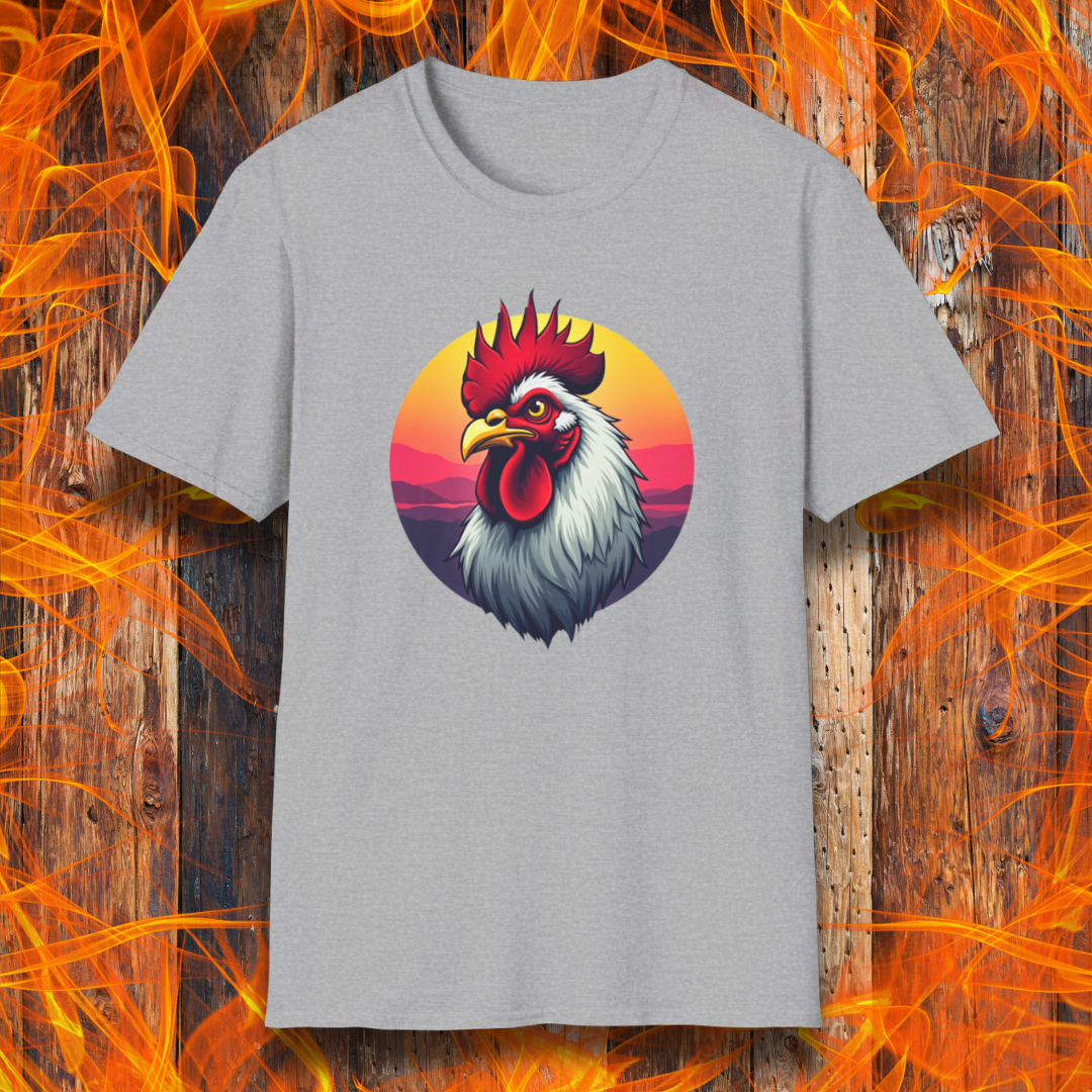 Sport Grey T-shirt featuring a bold and colorful illustration of a rooster with a dramatic red comb and white feathers, set against a circular sunset background with warm hues of orange, pink, and purple. The design exudes a rustic and vibrant aesthetic, perfect for BBQ and farm-style enthusiasts.
