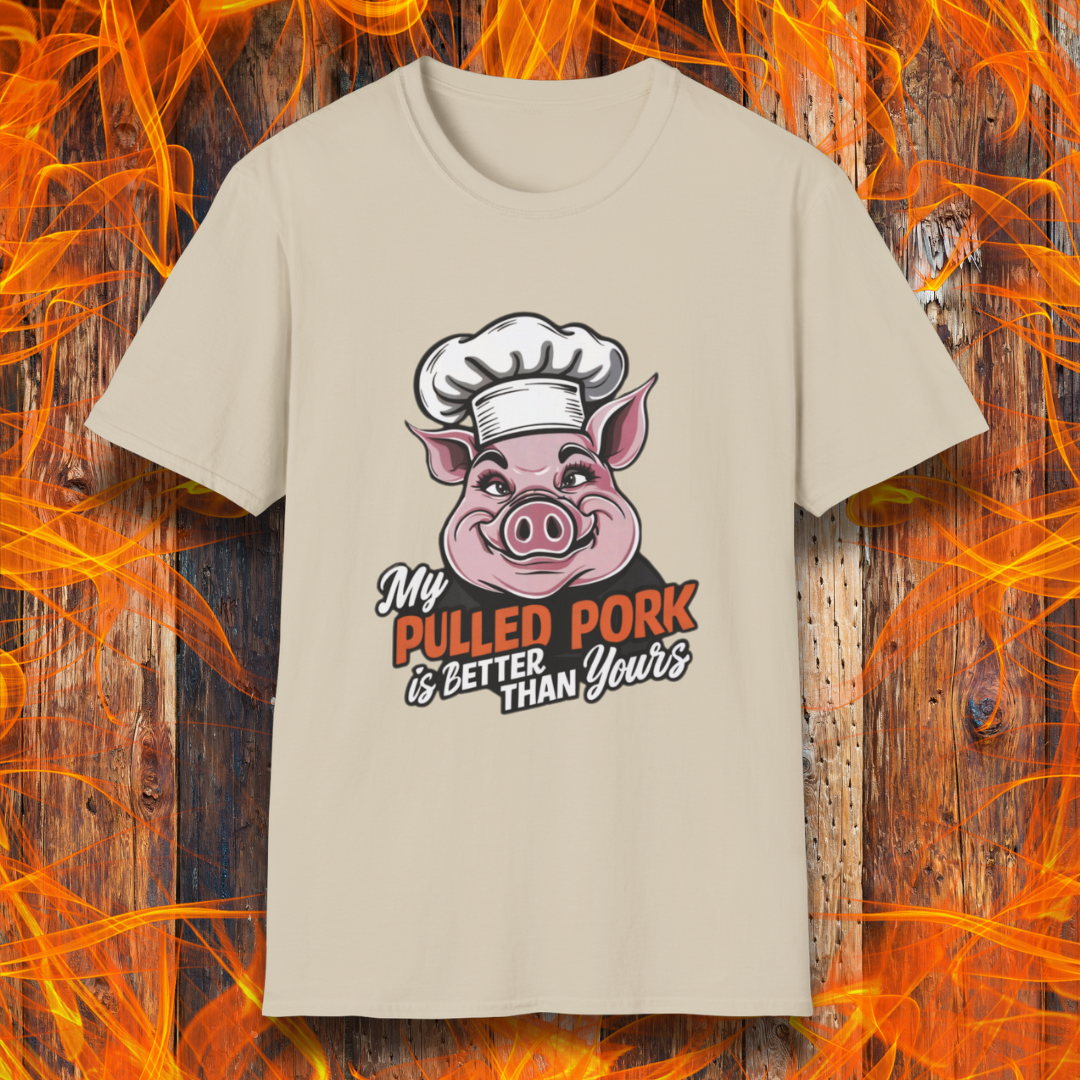 Sand T-shirt featuring a fun BBQ-themed design with a pink cartoon pig wearing a chef’s hat. The bold text reads 'My Pulled Pork is Better Than Yours' in a mix of white and red script and block lettering. Perfect for pitmasters who take pride in their slow-cooked pulled pork."