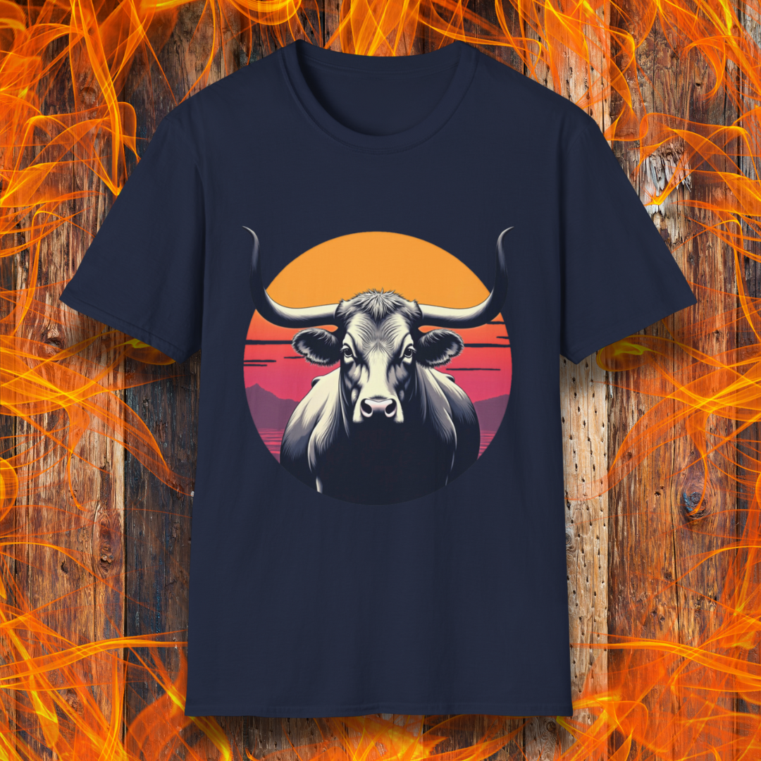 Navy T-shirt featuring a striking design of a longhorn bull staring forward with an intense gaze. The bull is set against a circular backdrop of a sunset with warm orange, red, and pink hues, along with silhouetted mountains in the background. The design conveys strength, confidence, and a bold Western aesthetic, appealing to BBQ and cattle enthusiasts.