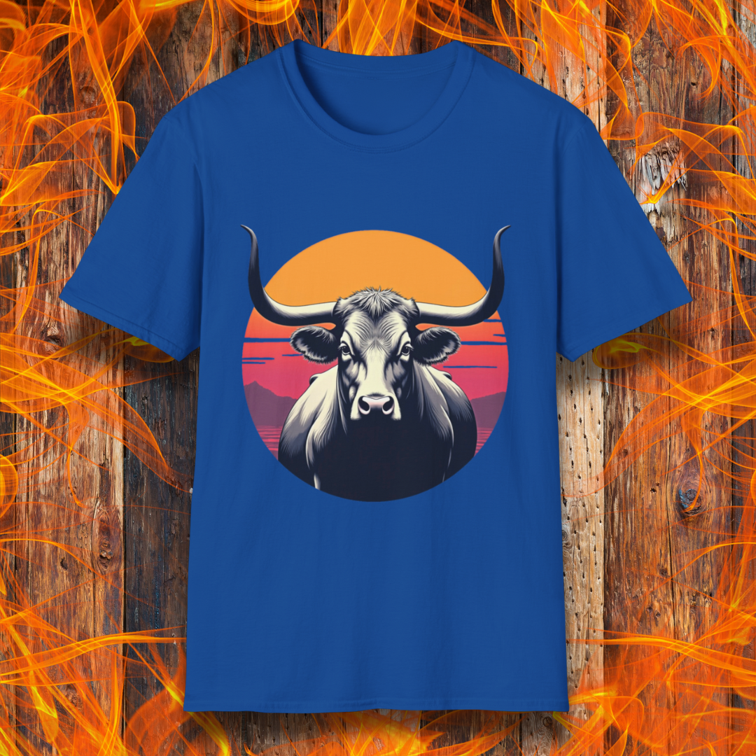 Royal Blue T-shirt featuring a striking design of a longhorn bull staring forward with an intense gaze. The bull is set against a circular backdrop of a sunset with warm orange, red, and pink hues, along with silhouetted mountains in the background. The design conveys strength, confidence, and a bold Western aesthetic, appealing to BBQ and cattle enthusiasts.