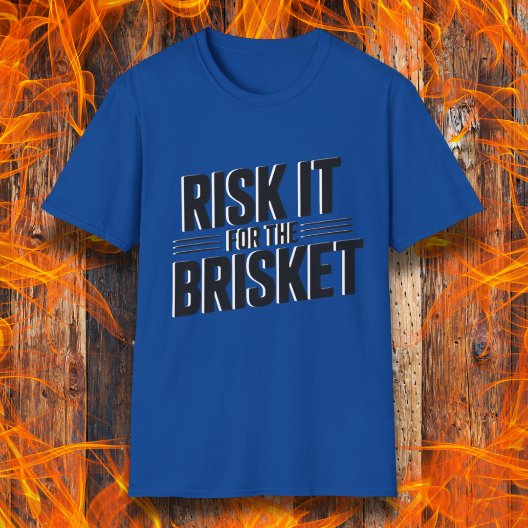 Blue t-shirt with 'RISK IT FOR THE BRISKET' text on a wooden background with flames.
