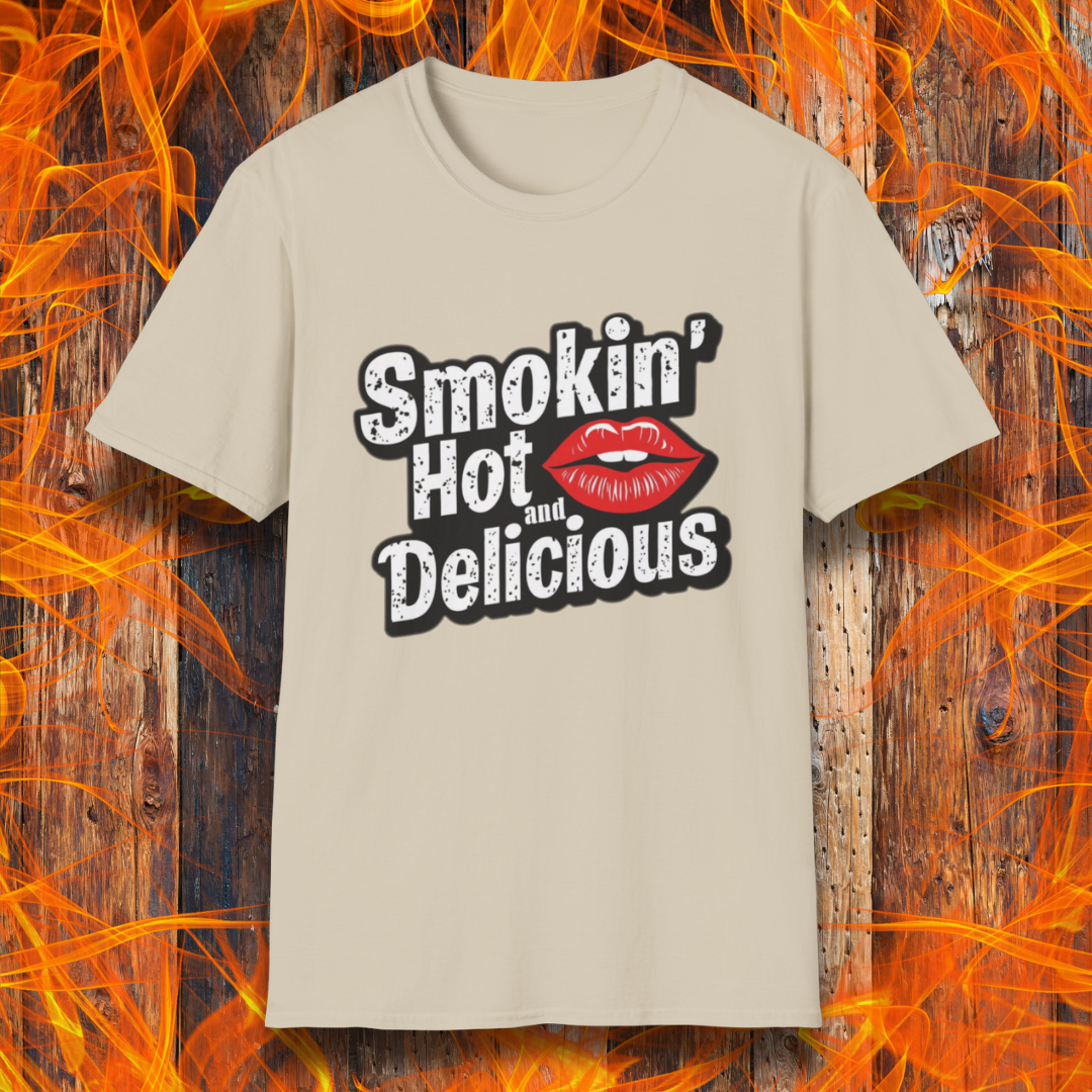 Sand t-shirt featuring bold white text that reads 'Smokin' Hot and Delicious,' with a red lips graphic replacing the 'o' in 'Hot' for a fun, flirty BBQ-inspired design