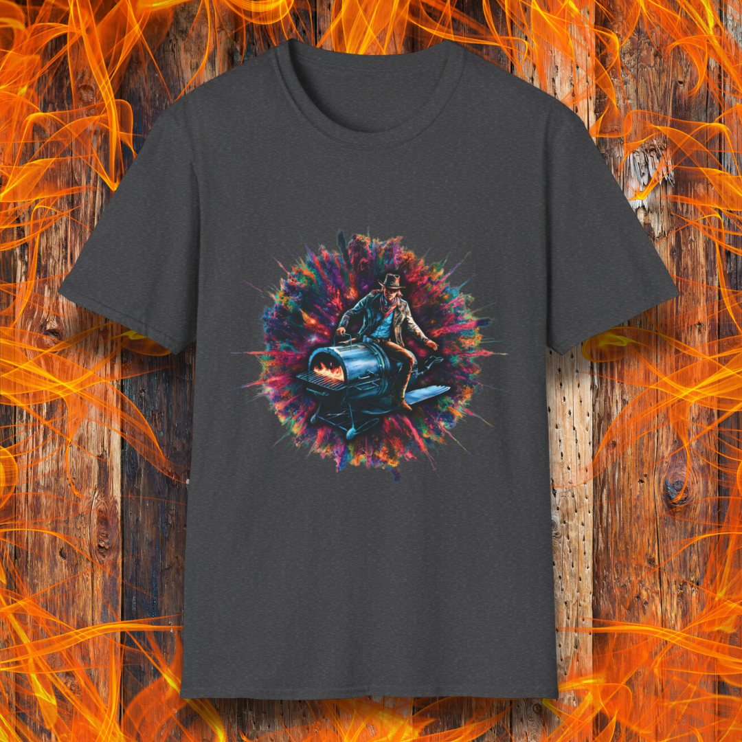Dark Heather T-shirt featuring a striking design of a cowboy riding a futuristic, rocket-powered barbecue smoker. The artwork is set against an explosive, colorful cosmic backdrop, blending elements of Western and sci-fi themes for a bold grilling statement.