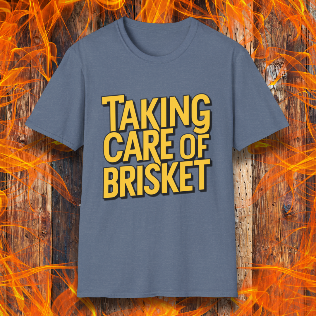 Heather Indigo T-shirt with bold yellow text reading 'Taking Care of Brisket,' a fun BBQ-themed design inspired by classic rock and grilling culture.