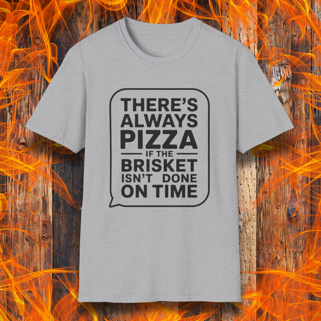 Sport Grey T-shirt featuring bold white text in a speech bubble that reads "There’s Always Pizza If the Brisket Isn’t Done on Time," displayed over a wooden background with flames — a humorous shirt for BBQ fans who know the struggle of low-and-slow cooking.