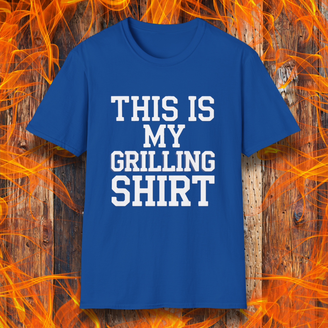 Royal Blue T-shirt with bold white text that reads "THIS IS MY GRILLING SHIRT." The shirt is displayed against a fiery wooden background, emphasizing its BBQ and grilling theme.