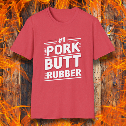 Heather Red T-shirt featuring a bold, humorous BBQ-themed design that reads '#1 PORK BUTT RUBBER' in red and white block lettering with stylish line accents. A fun shirt for grill masters and barbecue enthusiasts.
