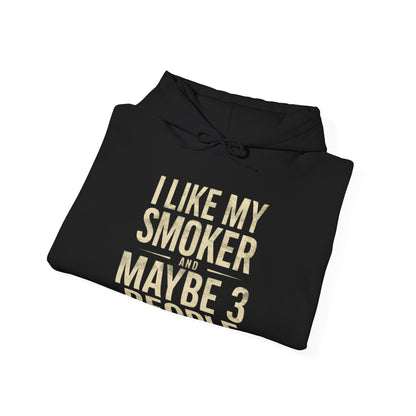 Black hoodie with gold text I Like My Smoker and Maybe 3 People” on a white background