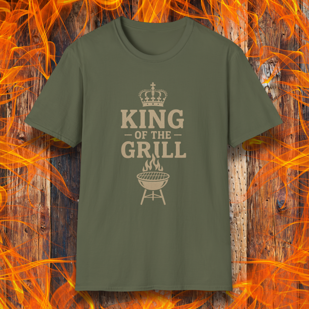 Green t-shirt with 'King of the Grill' text on a wooden background with flames.