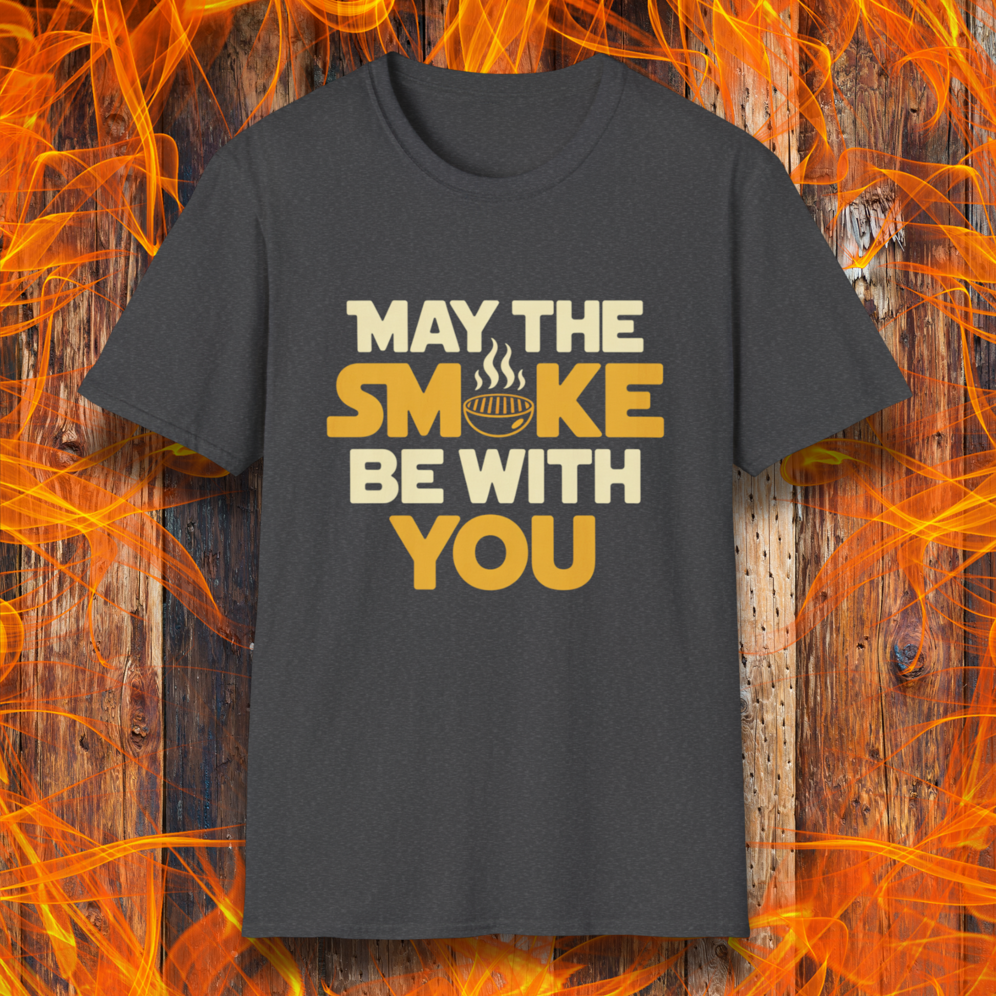 Black t-shirt with 'May the smoke be with you' text on a wooden background with flames.