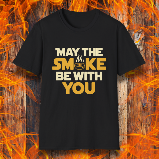 Black t-shirt with the phrase "May The Smoke Be With You" on a wooden fire background.