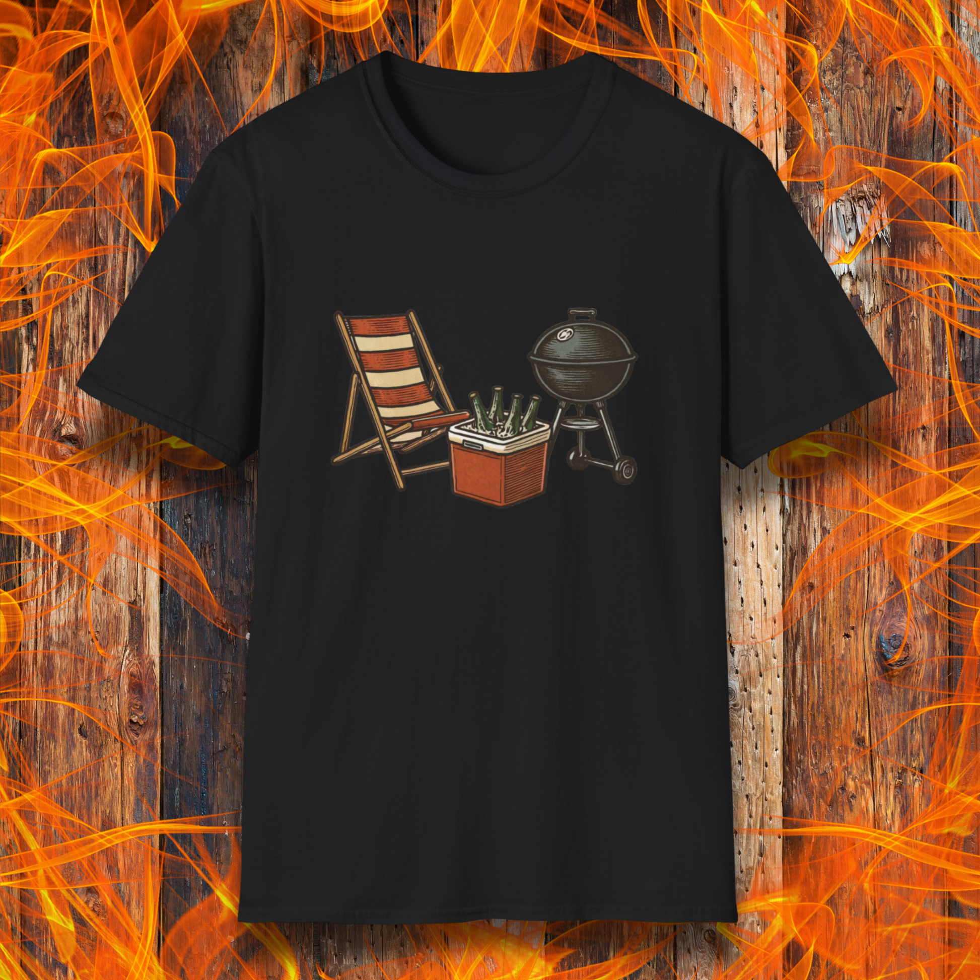 Black t-shirt with a graphic of a deck chair, cooler, and grill on a wooden background with flames.
