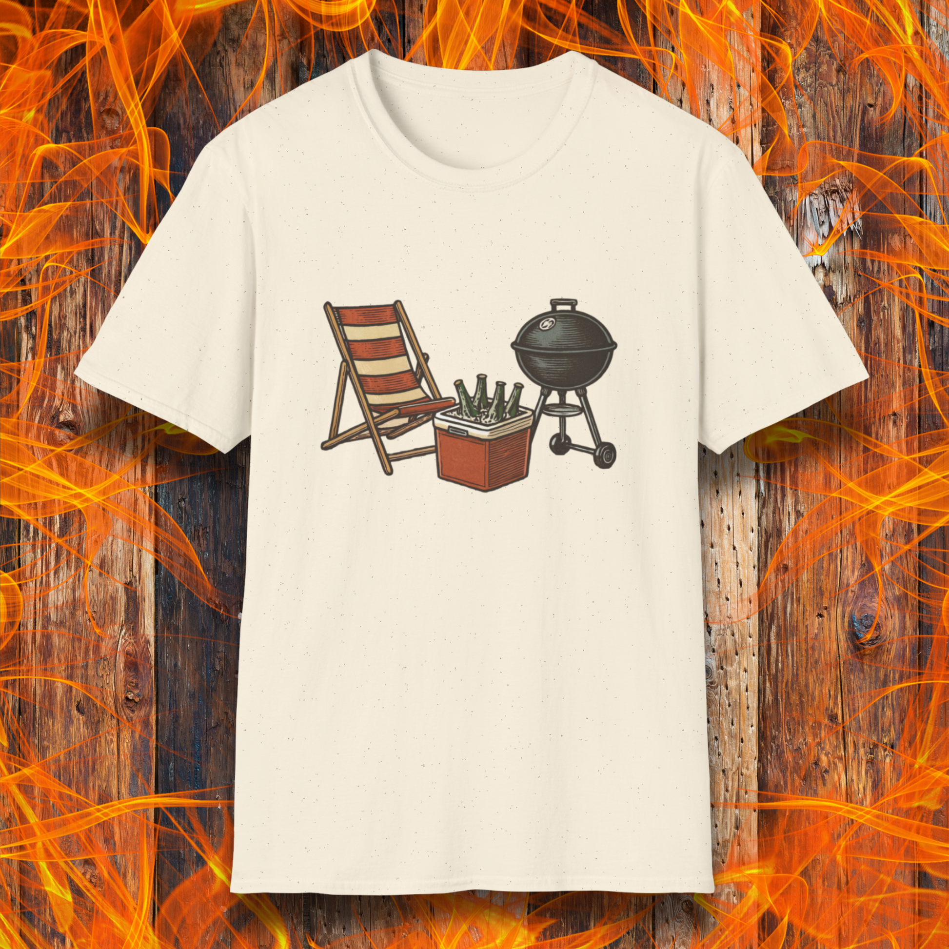 Beige t-shirt with a graphic of a chair, cooler, and grill on a wooden background with flames.