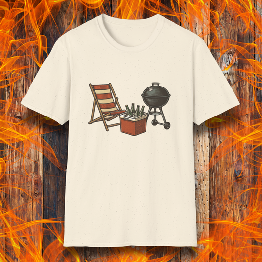 Beige t-shirt with a graphic of a chair, cooler, and grill on a wooden background with flames.