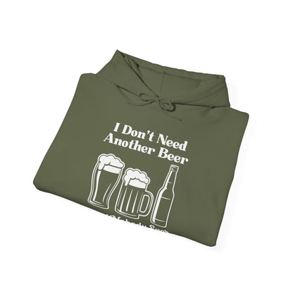 Folded olive green hoodie with white text "I don't need another beer said nobody ever" and graphics on a white background