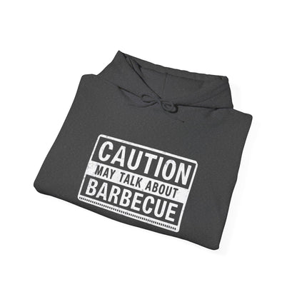 Folded gray hoodie with 'Caution: May Talk About Barbecue' text on a white background